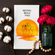 Resting Beach Face - Organic cotton tea towel with serene sunset and hibiscus line art for beach lovers.